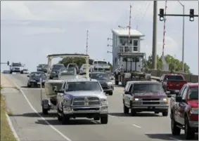  ?? CHUCK BURTON — THE ASSOCIATED PRESS ?? People drive over a drawbridge in Wrightsvil­le Beach, N.C., as they evacuate the area in advance of Hurricane Florence, Tuesday. Florence exploded into a potentiall­y catastroph­ic hurricane Monday as it closed in on North and South Carolina, carrying winds up to 140 mph and water that could wreak havoc over a wide stretch of the eastern United States later this week.