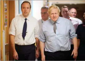  ?? Associated Press file photo ?? In this November 2019 file photo, British Prime Minister Boris Johnson, right, and Health Secretary Matt Hancock visit Bassetlaw District General Hospital in Worksop, England. Hancock tested positive for the novel coronaviru­s Friday, the same day as Johnson was confirmed to have COVID-19.