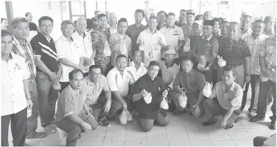  ??  ?? DR RAYONG bersama tetamu dan penerima bergambar bersama selepas penyerahan bubur lambuk dan bantuan Hari Raya di pekan Engkilili.