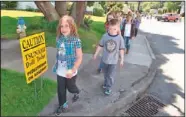  ??  ?? Students at the Blossom Gulch Elementary School walk single file during a tsunami drill Thursday in Coos Bay, Ore. During the drill, the students ducked under their desks, as if an earthquake was violently shaking the ground. Then they filed outside...