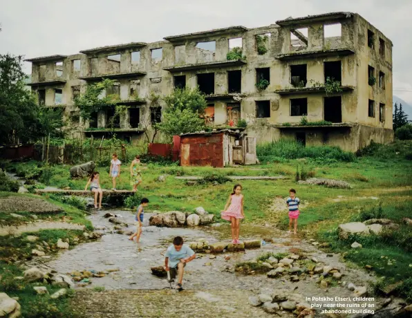  ??  ?? In Potskho Etseri, children play near the ruins of an abandoned building