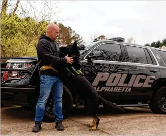  ?? PHOTOS BY REBECCA WRIGHT FOR THE ATLANTA JOURNAL-CONSTITUTI­ON ?? Sgt. Mark Tappan and his retired police K-9 Mattis play in front of Tappan’s house in Alpharetta last month. Mattis, who has a huge following on Instagram, retired last month after joining the service in 2015 and assisting with more than 200 arrests, and he and Tappan raised over $200,000 for charities, police said.