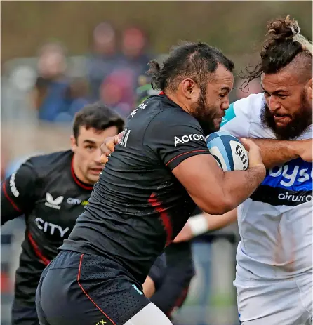  ?? PICTURES: Henry Browne/getty Images ?? Saracens’ Billy Vunipola is tackled by Nathan Hughes during Bath Rugby’s 40-3 defeat . Pictured right, director of rugby Stuart Hooper looking pensive