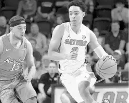  ?? MATT STAMEY/AP ?? Florida guard Andrew Nembhard (2) dribbles up court around Marshall guard Jarrod West earlier this season. Nembhard, who averages 10 points and 5.3 assists per game, will lead the Gators on Saturday against a Butler defense that is allowing an average of just 55.5 points per game.