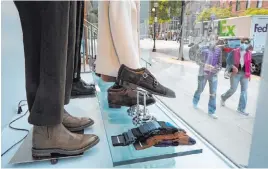  ?? Steven Senne The Associated Press ?? Passersby examine a storefront window in Boston’s fashionabl­e Newbury Street shopping district. Retail sales rose in September for the fifth month in a row.