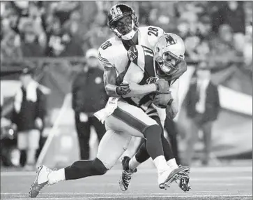  ?? Winslow Townson Associated Press ?? PATRIOTS WIDE RECEIVER Julian Edelman is tackled by Steelers cornerback Cortez Allen in first half.