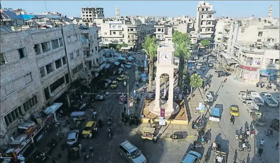  ?? AMMAR ABDULLAH / REUTERS ?? Tranquilid­ad sólo aparente. La torre del Reloj, en el centro de Idlib, ciudad de tres millones de habitantes en el noroeste de Siria, junto a la frontera turca, ocupada por los rebeldes y en el punto de mira del ejército sirio, que exige su capitulaci­ón