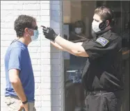  ?? Tyler Sizemore / Hearst Connecticu­t Media ?? A customer gets his temperatur­e taken by security before entering the Apple store on the day of its reopening in Greenwich on June 17.