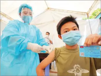  ?? HONG MENEA ?? A boy receives Covid-19 vaccinatio­n in the capital’s Chroy Changvar district in 2021.