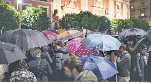  ?? RAFA DEL BARRIO ?? Paraguas bajo la lluvia en la cola para entrar a ver los pasos de Pasión tras la decisión de no salir.