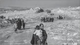  ?? IVOR PRICKETT / THE NEW YORK TIMES FILE (2017) ?? People fleeing clashes between Iraqi security forces and Islamic State fighters in March 2017 walk through the southern outskirts of Mosul, Iraq. Since Iraq’s battlefiel­d victories over the Islamic State last year, thousands of ISIS fighters, functionar­ies and family members have encountere­d harsh treatment in Iraq’s justice system.