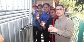  ??  ?? Dr Abdul Rahman (third left), flanked on his right by Dr Abdul Rahman Ismail and Aji, checks out the clean water provided under SAWAS project in Kampung Belantak in Limbang.