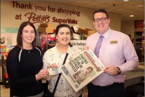  ??  ?? Amy Fenlon, Bellefield receives her €20 from Donna Murphy of People Newspapers and John Currid, assistant manager, Pettitt’s SuperValu, Enniscorth­y.