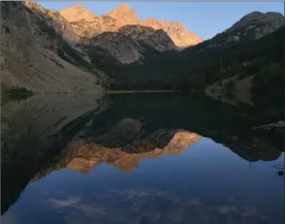  ?? PHOTOS BY MIKE ECKEL, THE ASSOCIATED PRESS ?? Pika Peak, shown at sunset, is mirrored in Echo Lake, one of scores that dot Montana’s Absaroka-Beartooth Wilderness. The region is popular for hikers and anglers alike.