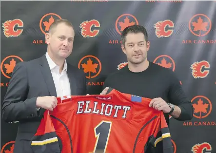  ?? JIM WELLS ?? General manager Brad Treliving, left, poses with Brian Elliott as the Flames' new goaltender is introduced to the media on Wednesday.