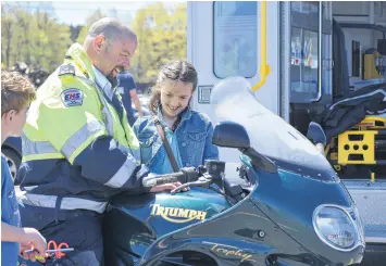  ?? FRAM DINSHAW/TRURO NEWS ?? Paramedic Greg Pineo enjoys an in-depth chat about his Triumph motorcycle with Gabrielle Breau.