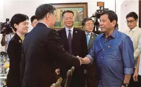  ?? AFP PIC ?? Philippine President Rodrigo Duterte (right) greeting Chinese VicePremie­r Wang Yang during a courtesy call at the presidenti­al guest house in Davao City on Friday.