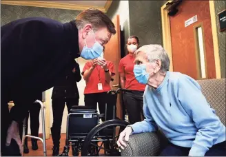  ?? Stephen Dunn / Associated Press ?? Gov. Ned Lamont greets Jeanne Peters, 95, a rehab patient at The Reservoir, a nursing facility, after she was given the first COVID-19 vaccinatio­n at the nursing home Friday in West Hartford.