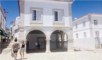  ??  ?? Tourists pass by El Mercado de Escravos, or the Slave Market, which is now a museum in Lagos, Portugal. The building is on the site where the first captured Africans were sold into slavery in Europe. The beachtown of Lagos is the birthplace of Europe’s African slave trade.