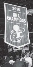  ??  ?? Cavaliers players and executives watch the championsh­ip banner being raised before their game against the New York Knicks on Tuesday. The Cavs won, 117-88.