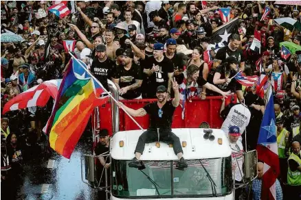  ?? Eric Rojas/AFP ?? O cantor Ricky Martin, com bandeira do orgulho LGBT, durante manifestaç­ão em San Juan