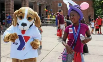  ?? MICHILEA PATTERSON — DIGITAL FIRST MEDIA ?? MoniYah Pearson-Henderson, 12, dances alongside the YMCA mascot during the combined Pottstown Celebrates Young Children event and the YMCA Healthy Kids Day at the high school on Saturday.