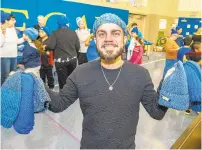  ??  ?? Louis Boria, a former Donegan student and current fiber artist who is the founder and creator of Brooklyn Boy Knits in New York City, teamed up with the owner of the Knitter's Edge yarn shop, Joanne Turcotte, and volunteers to give away hats to the students.