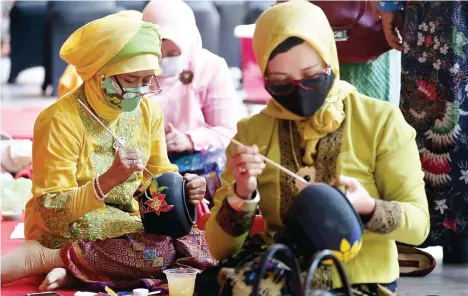  ?? GUSLAN GUMILANG/JAWA POS ?? LINTAS GENERASI: Tri Sugesti Ratna Sukarini, warga Griyo Mapan, ketika mengikuti sesi melukis gerabah pada acara lintas generasi Kartini Art Festival di favehotel Sidoarjo kemarin.