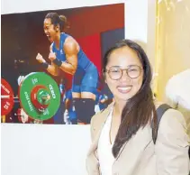  ?? ?? Hidilyn Diaz, Philippine­s’ first Olympic gold medalist, beside her captured victorious moment by Agence France-Presse’s Vincenzo Pinto.