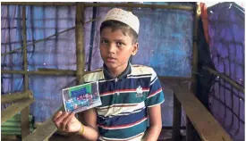  ?? — AFP ?? Bare necessitie­s: Ayaz with his family photo and Asaru (right) with her cooking pots in the refugee camp near the Bangladesh-Myanmar border.