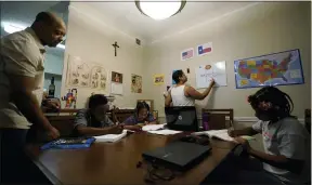  ?? ERIC GAY — THE ASSOCIATED PRESS ?? Arlena Brown, center, holds her youngest child, Lucy, 9months, as she and husband, Robert, left, lead their other children, from left, Jacoby, 11; Felicity, 9, and Riley, 10, through math practice July 13at their home in Austin, Texas. “I didn’t want my kids to become a statistic and not meet their full potential,” said Robert, a former teacher who now does consulting. “And we wanted them to have very solid understand­ing of their faith.”