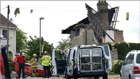  ??  ?? Aftermath...rescue workers at the scene of the horrific blast yesterday