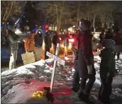  ?? JEFF WHEELER — STAR TRIBUNE VIA AP ?? People demonstrat­e by a cross planted in the boulevard outside homes at the intersecti­on of Dean Parkway and W. 28th St. in Minneapoli­s on Sunday night.