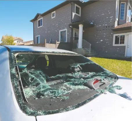  ?? GAVIN YOUNG ?? The aftermath of Saturday’s intense hailstorm shows in a damaged home and car in Saddle Ridge in northeast Calgary on Monday.