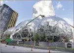  ?? THE ASSOCIATED PRESS FILE ?? In this April 27, 2017file photo, constructi­on continues on three large, glass-covered domes as part of an expansion of the Amazon. com campus in downtown Seattle.