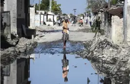  ?? MATIAS DELACROIX AP ?? A woman stands on one of the streets of the gang-controlled Cite Soleil neighborho­od of Port-au-Prince, Haiti, in November.