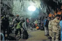  ?? Picture: AFP ?? DESPERATE MEASURES: Thai rescue personnel on Tuesday at the entrance of the flooded Tham Luang cave, under floodlight­s. Rescuers have been unable to reach the missing members of the children’s football team and their coach, due to rising water levels...