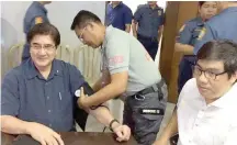  ?? PHOTO FROM BIÑAN POLICE STATION ?? GRINGO SURRENDERS Sen. Gregorio Honasan 2nd gets his blood pressure checked after voluntaril­y surrenderi­ng to Biñan, Laguna police on Friday. Police also took his mug shots (inset).