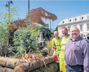  ??  ?? ●●Council landscape operatives Tony Nicholls and Jamie White, with environmen­t chief Coun Neil Emmott at the dinosaur garden