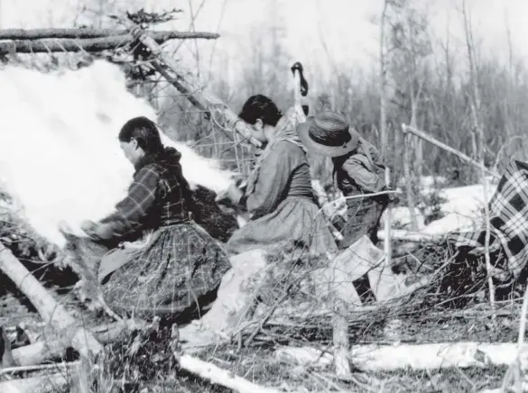  ??  ?? Above: Margaret Sayene and her mother-in-law dress a moose hide while an unidentifi­ed boy looks on in this photo by Henry W. Jones from circa 1905–15. The image appeared in the March 1946 issue, within an article on life in the Mackenzie River region of the Northwest Territorie­s in the early 1900s.
Left: A pair of Inuit girls, possibly Lucy and Agnes Oliktoak, play on a swing at Holman, now Ulukhaktok, N.W.T., in August 1961. The photograph is by Villy Svarre.