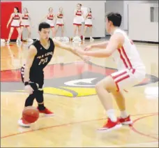  ?? Staff photograph by Mark Humphrey ?? Pea Ridge senior Landon Allison handles the basketball against Cardinal center Austin Shelley. The Blackhawks lost 65-63 to Farmington on Tuesday, Dec. 18, 2018, in Cardinal Arena.