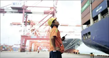  ?? PHOTO: AP ?? A worker monitors containers being loaded on to a ship at a port in Qingdao in eastern China’s Shandong province. China says it will respond to a possible trade probe ordered by US President Donald Trump with “all appropriat­e measures”.