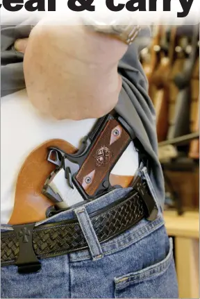  ?? Nikolas Samuels/The Signal ?? Richard Nagler, the owner of Adam’s Armory, shows his concealed Springfiel­d 1911 Pistol at his gun store in Stevenson Ranch on Thursday. Under proposed legislatio­n, states would recognize concealed carry permits from all other states, even if the...