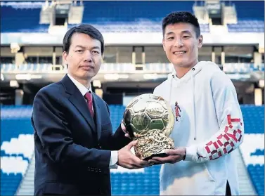  ??  ?? BALÓN DE ORO PERICO. Luo Ming le hace entrega del premio a Wu Lei como mejor jugador chino.