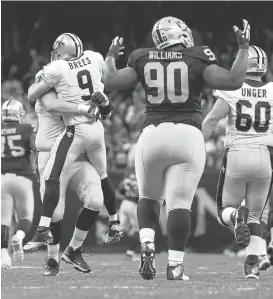  ?? SEAN GARDNER/GETTY IMAGES ?? Raider defenders like end Dan Williams (90) are having a tough time stopping such stars as Saints quarterbac­k Drew Brees (9), celebratin­g after throwing a 98-yard touchdown pass.