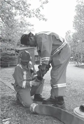  ??  ?? Crews set up water lines to protect Waskesiu on Friday as the area prepares for the possible spread of the Rabbit Creek wildfire that has burned thousands of hectares in Prince Albert National Park. PARKS CANADA