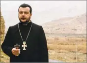  ?? The Armenian Prelacy ?? BISHOP Nshan Topouzian prays in 2005 as soldiers across the border in Djulfa destroy khachkars.