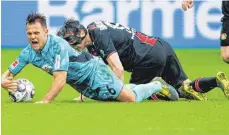  ?? FOTO: DPA ?? Maskenball – Julian Baumgartli­nger und Freiburgs Amir Abrashi (vorn) bei der gekrabbelt­en Polonaise. Die Punkte blieben aber in Leverkusen.