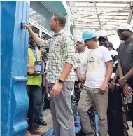  ??  ?? Prime Minister Andrew Holness (second left) paints a section of a wall at Ward Theatre in downtown Kingston on Labour Day, as part of activities to restore the 105-year-old monument. Also pictured are Mayor of Kingston and St Andrew, Councillor Delroy...