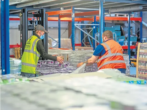  ??  ?? CHARITABLE: Volunteers at FareShare in Dundee prepare pallets for distributi­on to foodbanks to meet the extra demand during the pandemic.